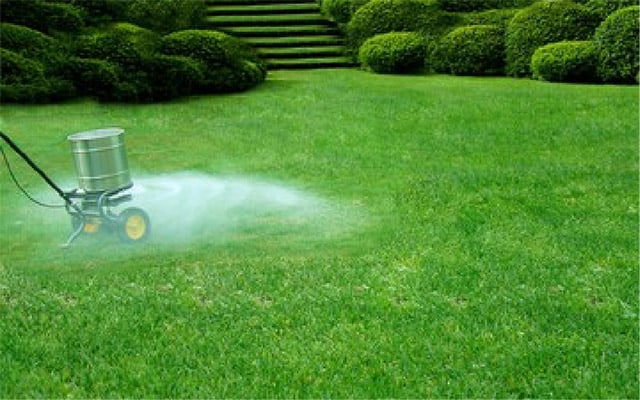 An application machine applying fertilizer to a healthy lawn